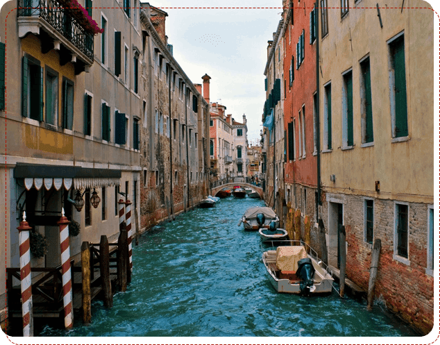 A canal with boats in it and buildings on the side.